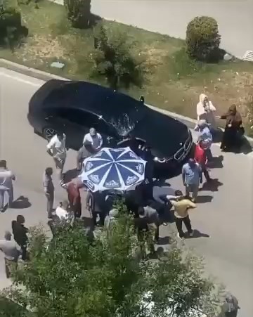 Vatandaşlar yerdeki yaralıyı güneşten korumak için dondurma şemsiyesi kullandı